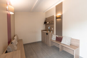 Coin salon avec bancs en bois et étagères.