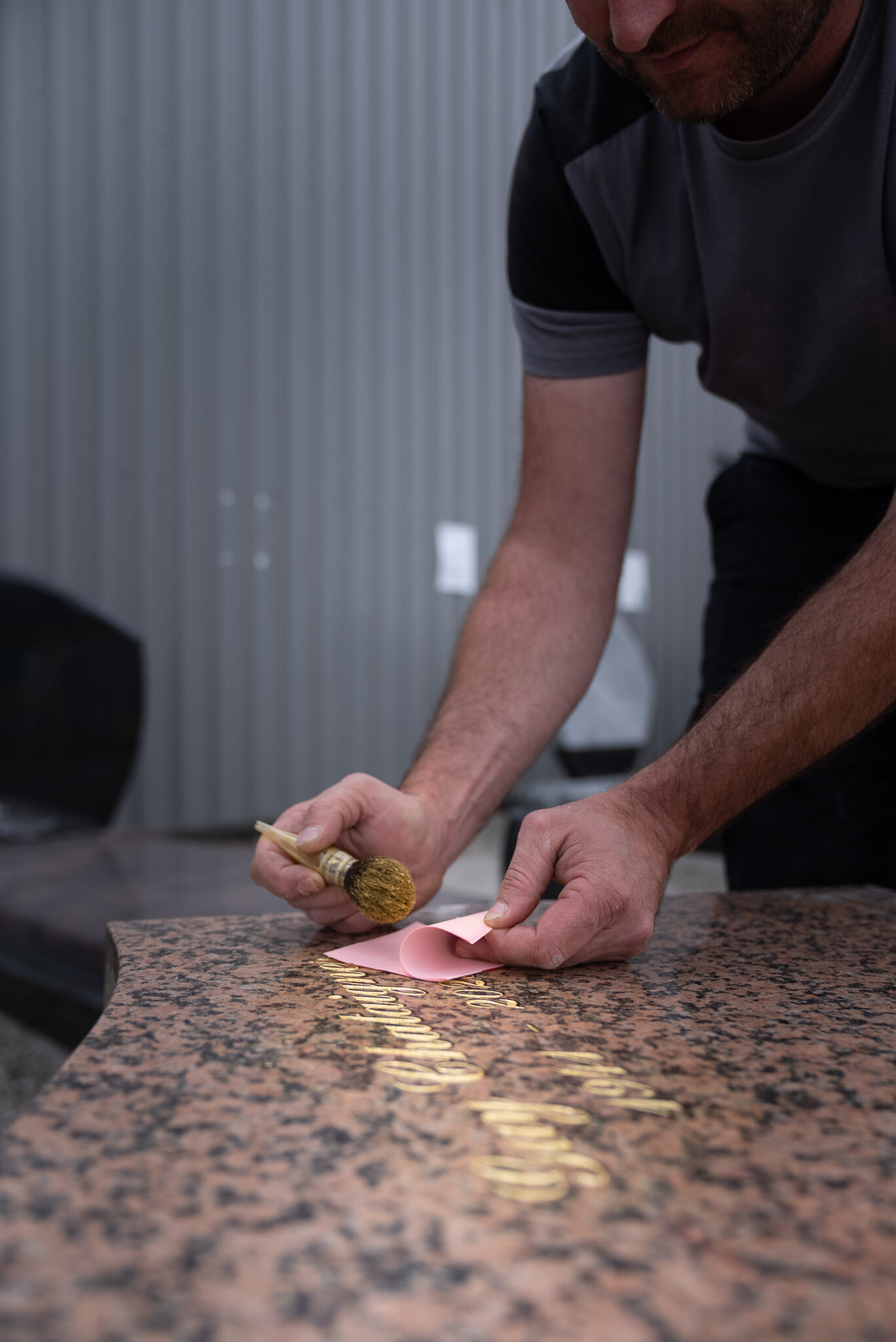 Personne nettoyant gravure sur pierre tombale en marbre.