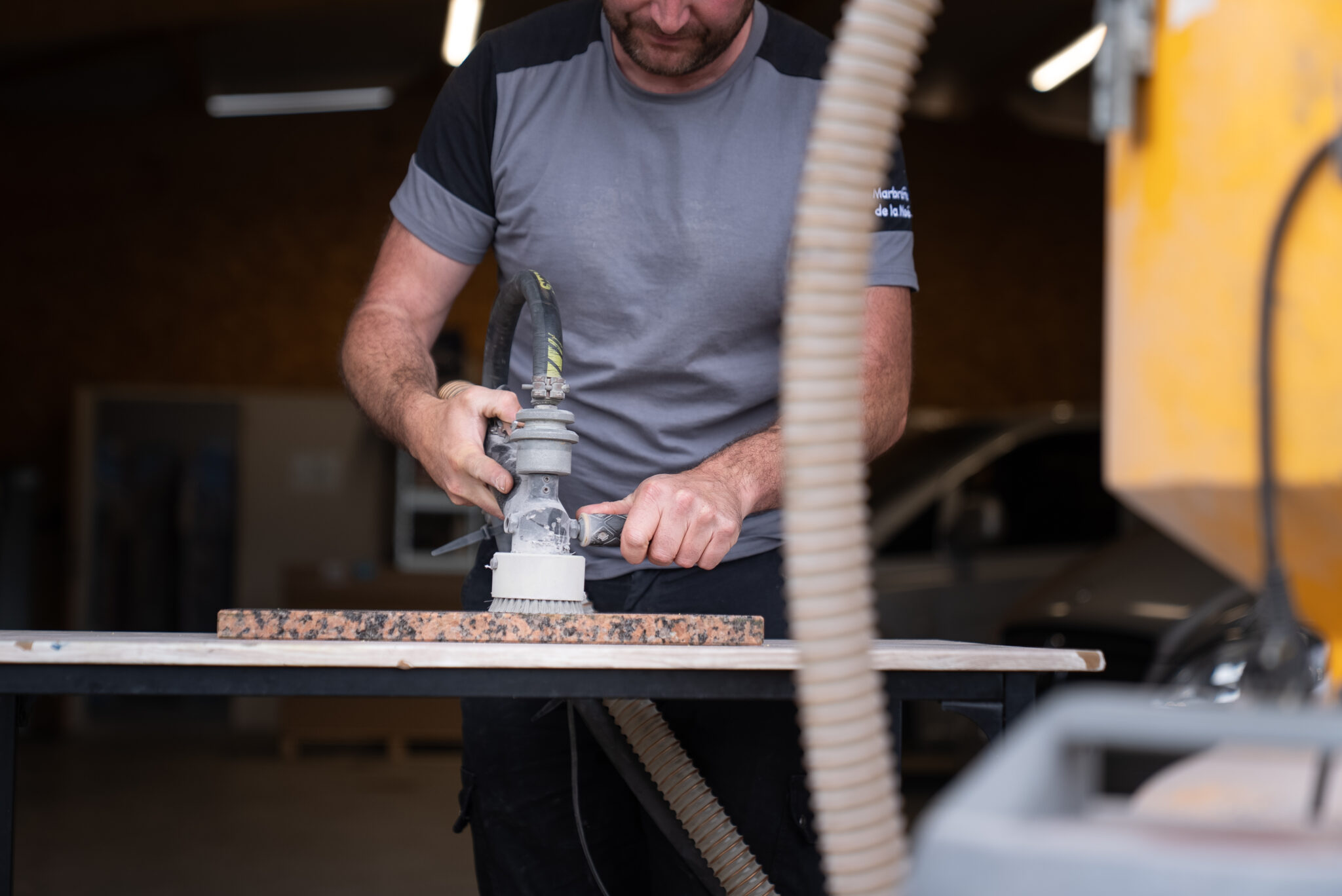 Homme travaillant le bois avec une ponceuse.