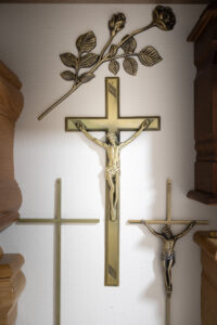 Croix et roses en métal doré sur mur.