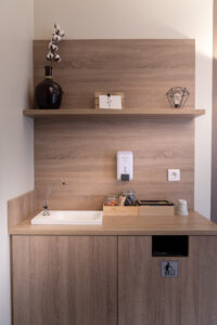 Mini-cuisine moderne avec évier et étagère.