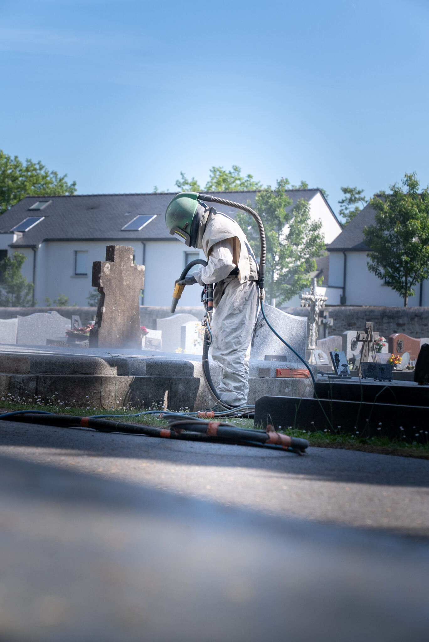 Nettoyage de tombes dans un cimetière avec équipement spécialisé.