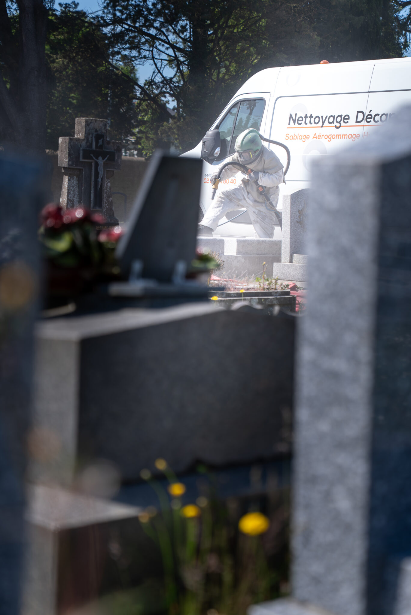 Nettoyage de tombes dans un cimetière.