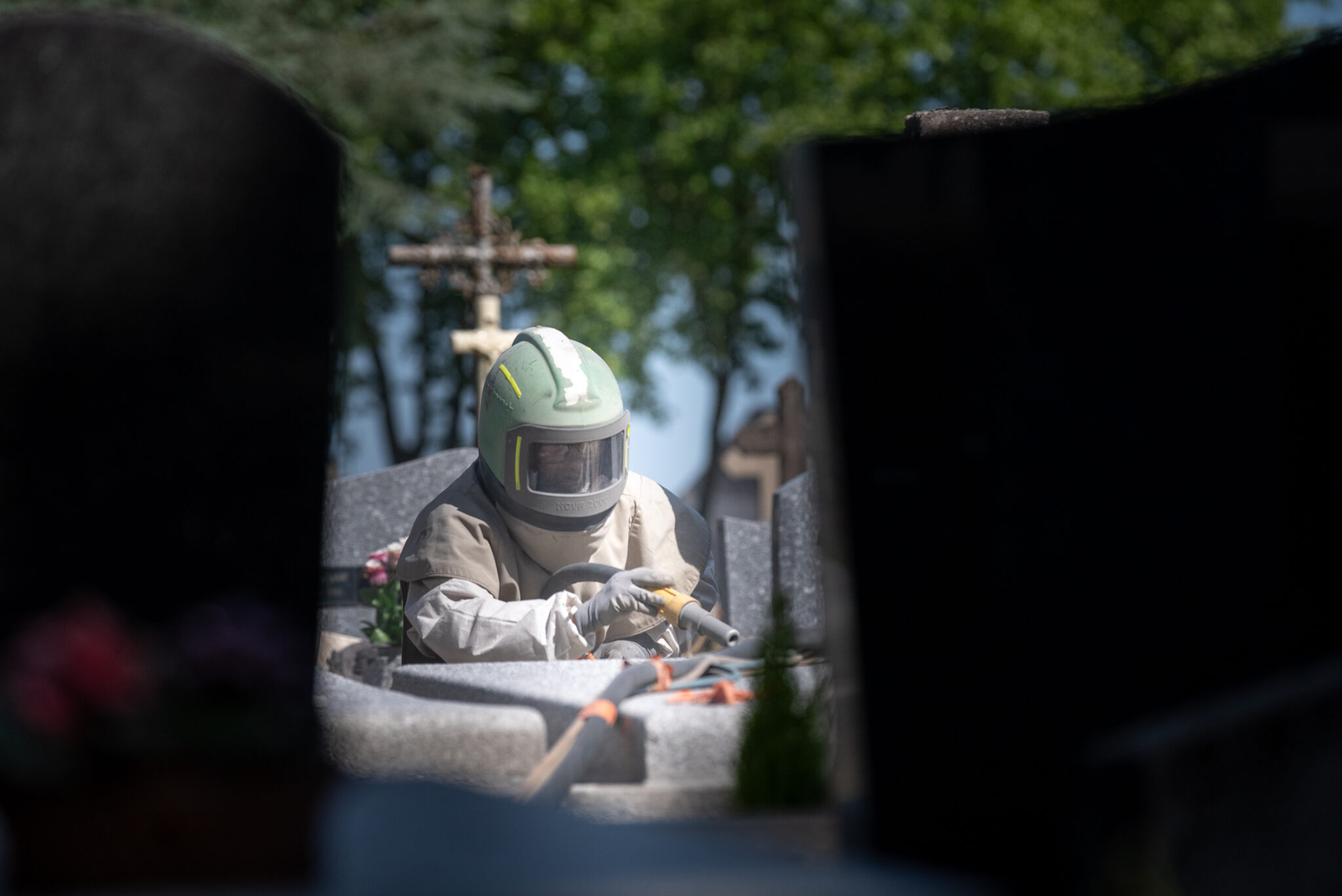 Personne en combinaison travaillant sur une tombe.
